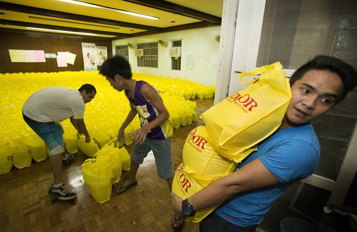 umcor-philippines-typhoon-haiyan-vincent-salazar Volunteer Vincent Salazar (right) helps a team with the United Methodist Committee on Relief in Manila as they load bags of relief supplies for survivors of Typhoon Haiyan in the Philippines.